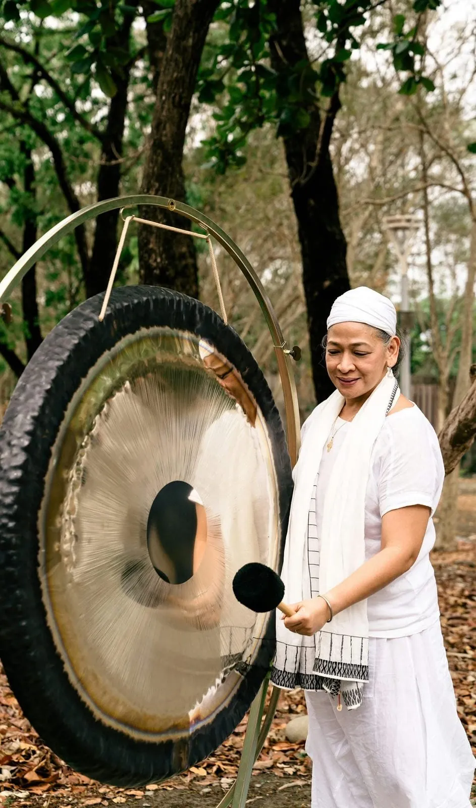 Juariza Aparis playing the gong outdoors